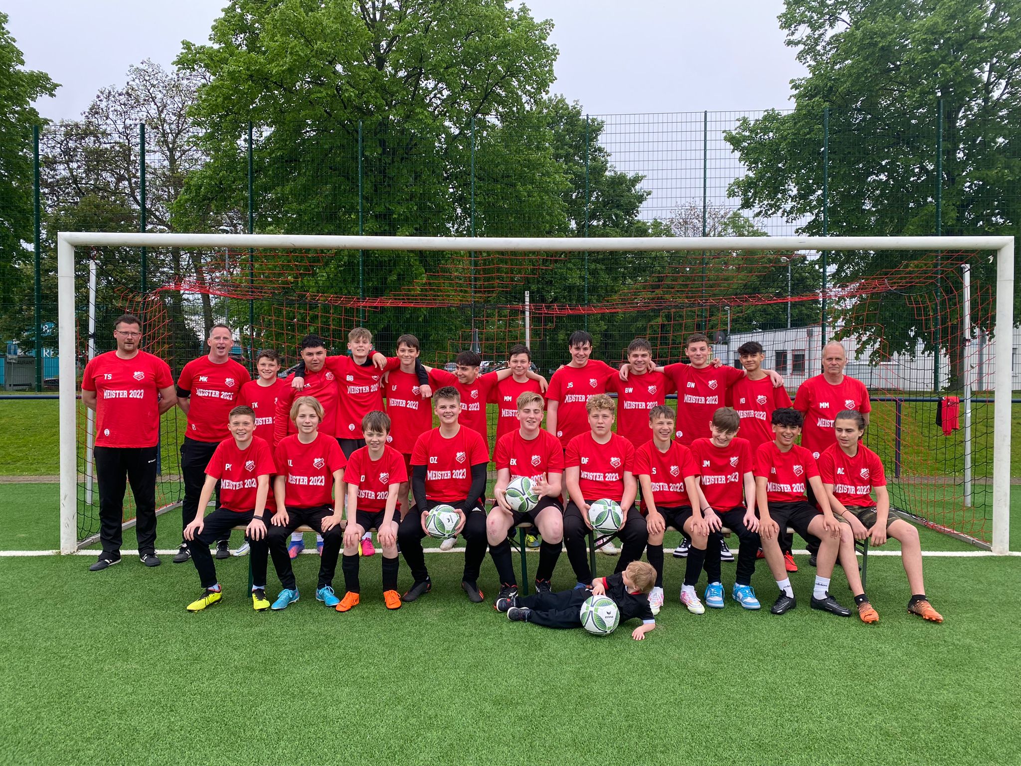 Mannschaftsfoto mit Meistershirts der C2-Junioren aus der Saison 22/23 mit den Trainern