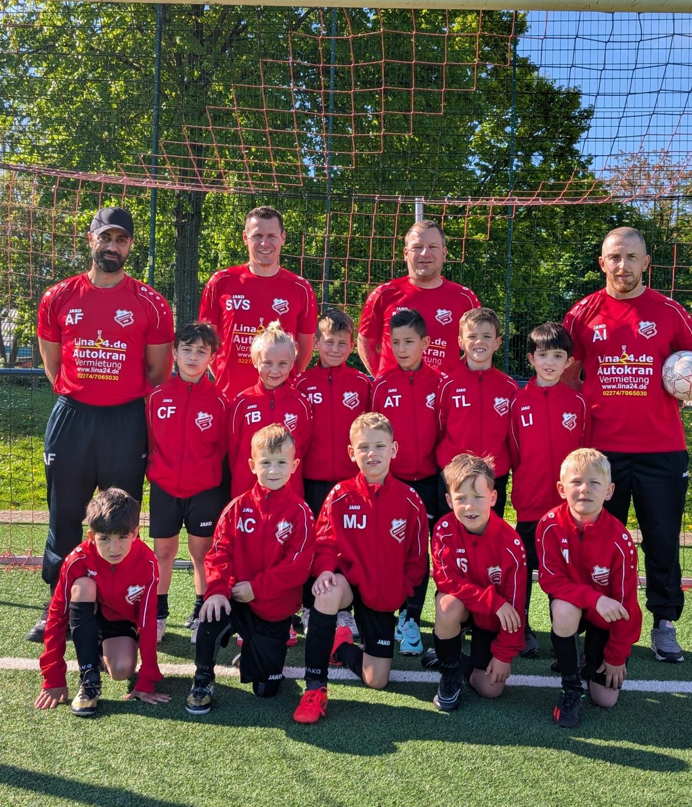 Mannschaftsfoto der F2-Junioren U8 mit den Trainern Ali Firat, Antonio Illiano, Sven Schmidt und Matthias Jendrzewski aus der Saison 24/25